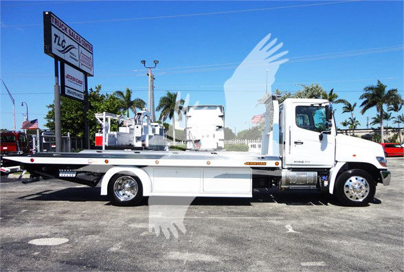 2022 Hino 268A tow truck side view with flatbed, chrome wheels, and white cab; stock number J51795.