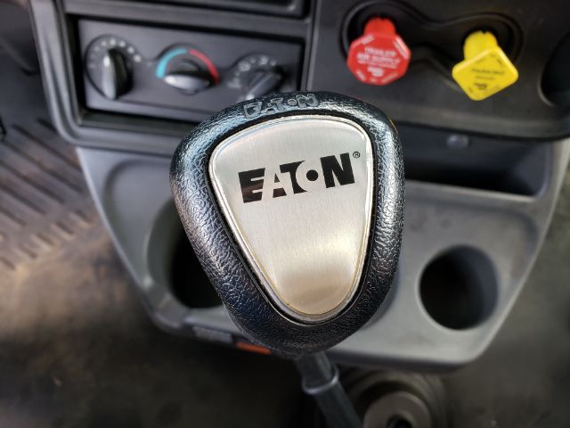 Eaton gear shift knob in cab with dashboard controls and colored indicators visible.