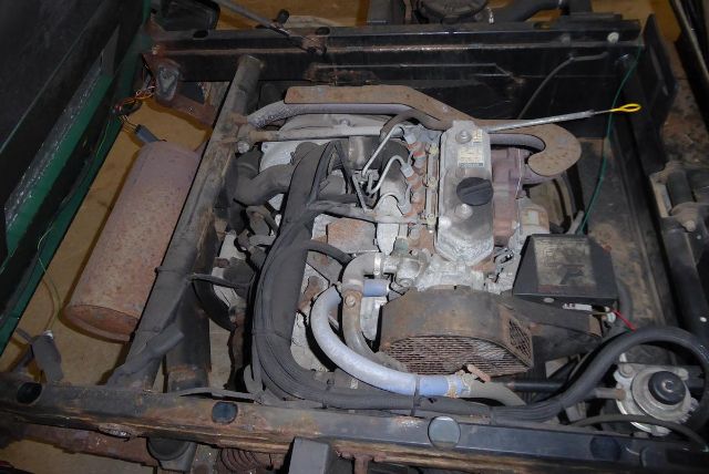 Kawasaki engine bay showing exposed components, hoses, and a radiator in a truck equipment setup.