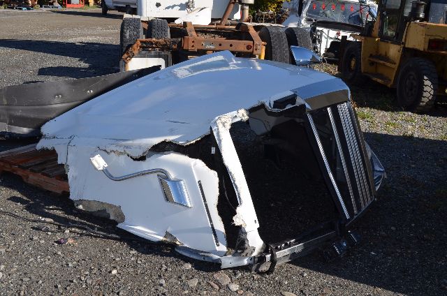 Front cab section of a damaged 2017 Western Star 5700 XE truck, white fiberglass/metal body with crumpled front grille and exposed inner structure.