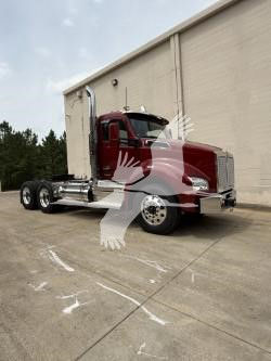 Kenworth T880 conventional daycab truck side view showing red cab and chrome exhaust stacks.