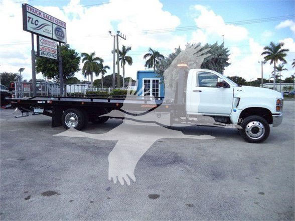 White 2023 International CV tow truck with flatbed, VIN 1HTKTSWK2PH441633, stock J41633, at a dealership lot with palm trees in background.