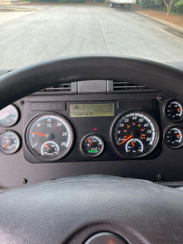 Freightliner Cascadia dashboard view showing analog gauges and digital display; steering wheel at bottom, odometer around 66,548 miles, N gear indicator.