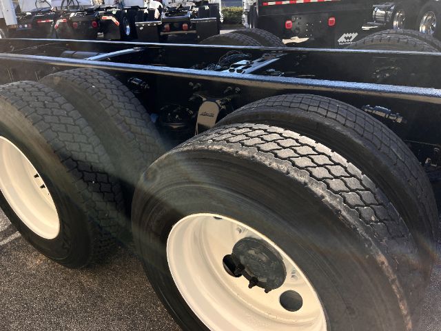 Dual rear axles with heavy-duty tires on Freightliner M2 chassis showing wheel rims and frame.