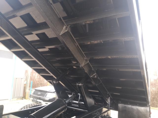 Freightliner M2 dump truck bed interior side showing hydraulic mechanism and steel bed ribs.
