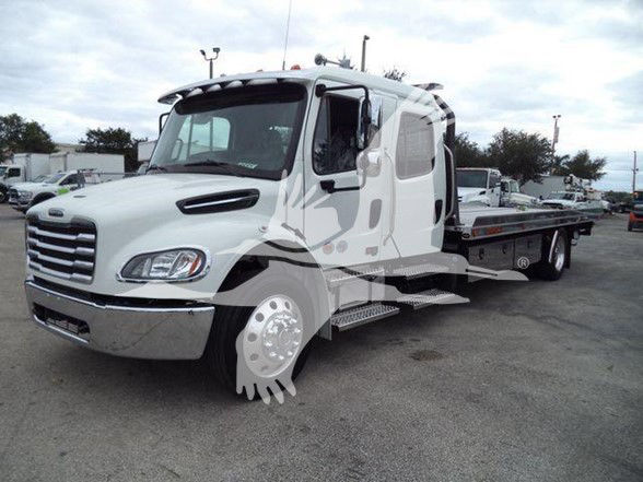 Freightliner Business Class M2 106 tow truck front left view with flatbed; cab shows large grille, headlights, and steps; watermark overlay on image.