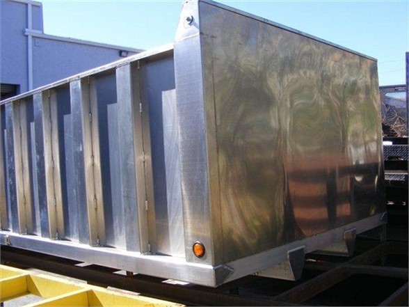 12 ft dump body trailer with metal panels, side view showing shiny stainless steel body and rear panel, with light on corner.