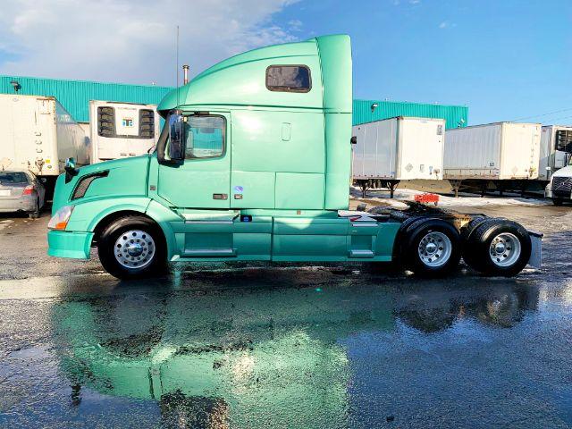 Volvo VNL 670 sleeper cab tractor in mint green, side profile view, 6x4 with dual rear axles and chrome wheels.
