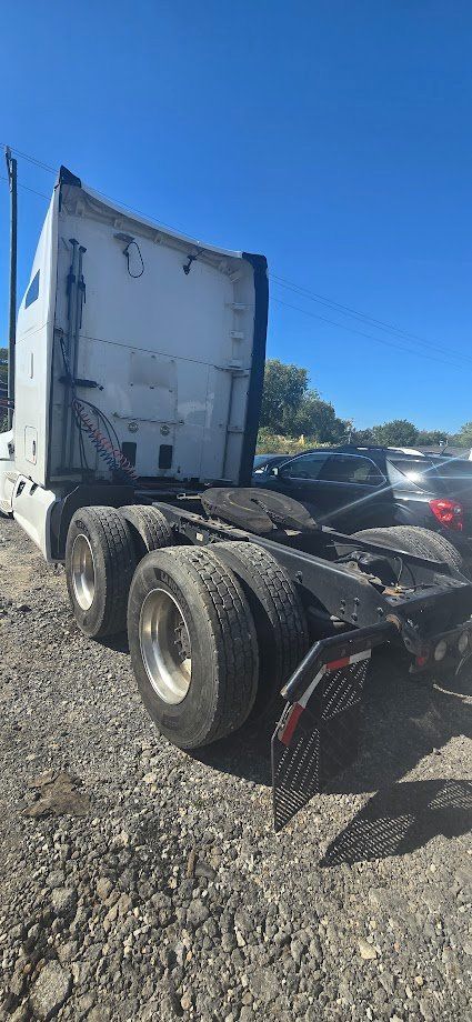 Kenworth truck rear cab area with triple rear axles and fifth wheel visible. No legible labels visible in this angle.