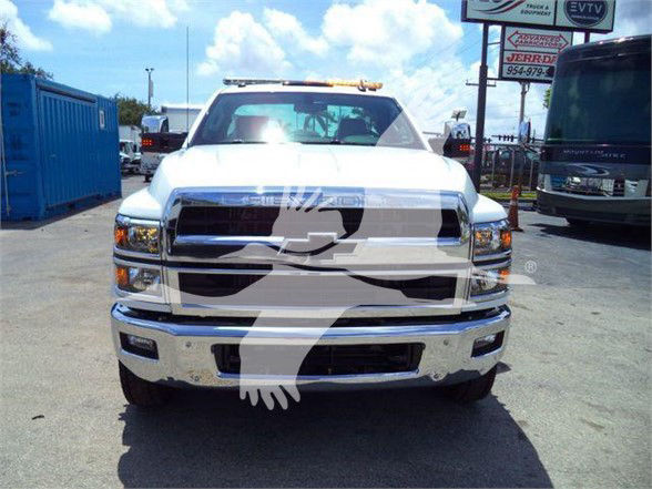 Front view of a white 2023 Chevrolet Silverado 6500HD truck with prominent grille and bumper in a dealership lot.