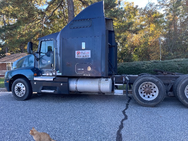 Kenworth T600 tractor in blue with sleeper, side view showing fuel tank and rear axles.