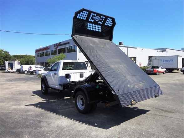 Ram 5500 HD hooklift truck with tilted aluminum bed and high rear tool/lighting panel visible