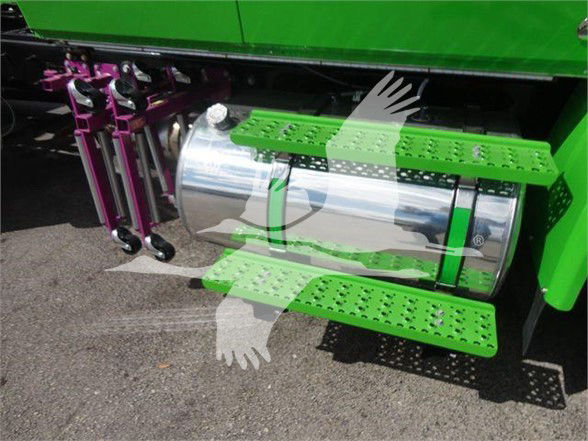 Truck side step with chrome fuel tank and green step covers showing steps and purple suspension components.