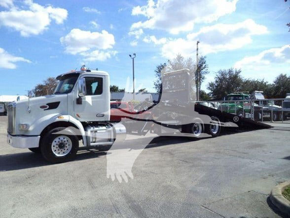 White 2016 Peterbilt 567 yard truck with a lowbed trailer in a parking lot.