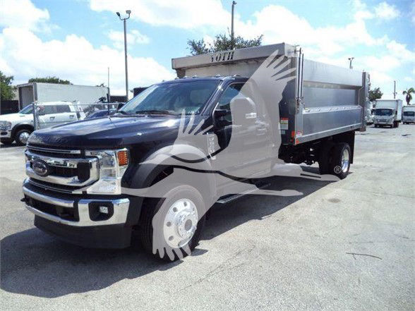 Ford F-550 dump truck with black cab and silver dump bed, front grille and headlights visible; dealership watermark overlays the image.