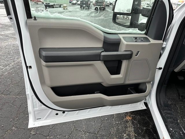Truck door interior panel showing beige and black colors with window controls, storage pocket, and armrest.