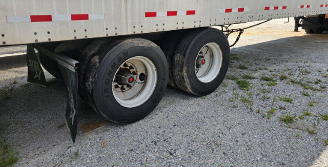 Trailer wheels and tandem axles visible under a Vanguard VXP utility trailer.
