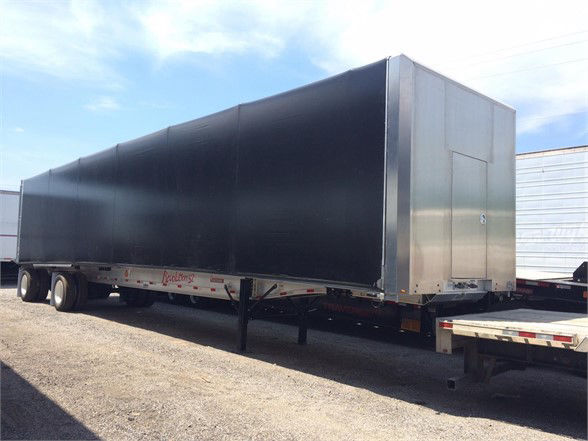 2024 Fontaine LOAD COVERING SOLUTIONS tarp system trailer with black tarp and silver front door.