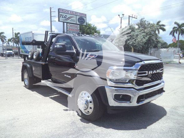 2024 Ram 5500 SLT tow truck with front chrome bumper and dual rear wheels, black cab, RAM grille, side steps, and flatbed equipment.