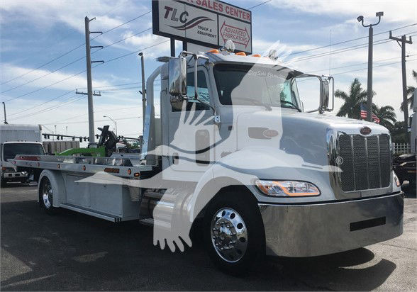 2022 Peterbilt 337 tow truck shown from front-left side with chrome bumper and flatbed body.