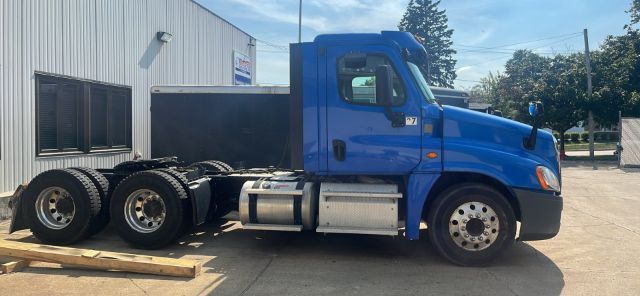 Freightliner Cascadia 2016 blue conventional daycab tractor side view showing cab, fuel tanks, and dual rear axles.