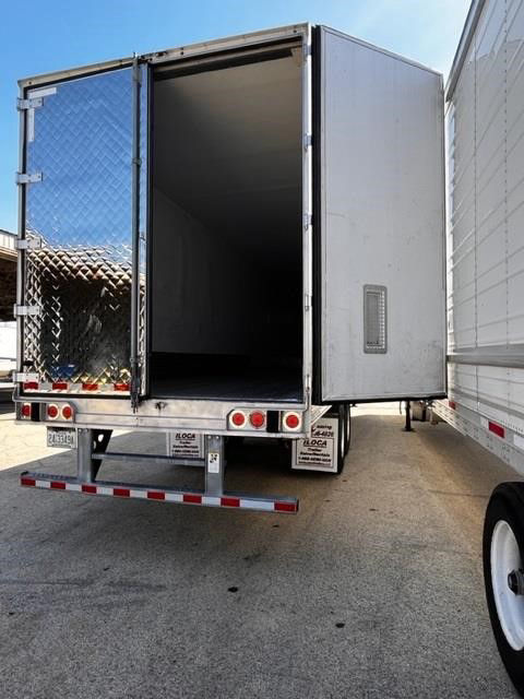 Trailer rear view showing open cargo space of 2015 CIMC COOL GLOBE reefer trailer with diamond plate rear door and taillights.