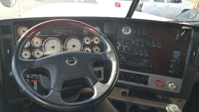 Truck cab dashboard of a 2013 Freightliner Coronado 132 showing steering wheel and instrument cluster with various gauges and control panels.