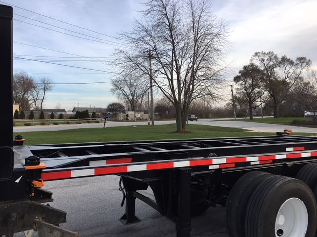 Trailer chassis and tipper-prone flatbed section showing side rails and wheel axles.