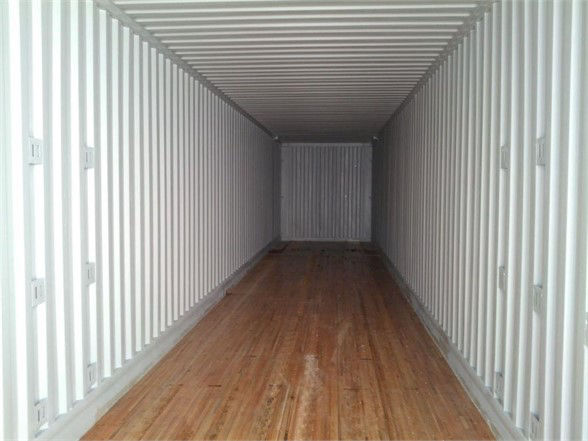 Interior of a CIMC container trailer with wooden floor and white corrugated metal walls, empty and rectangular.