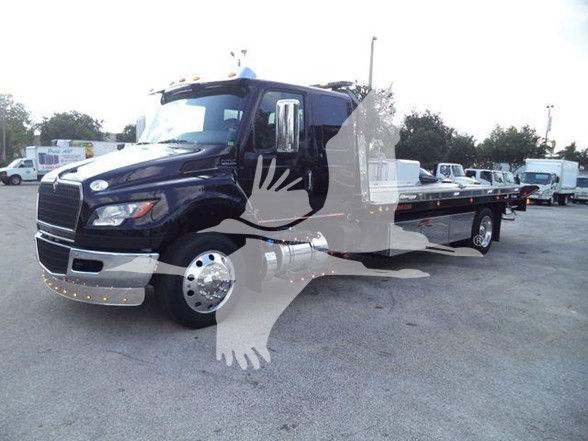Tow truck showing a 2024 International MV with a chrome front grille and long flatbed. Visible text: no legible label text on truck surfaces.