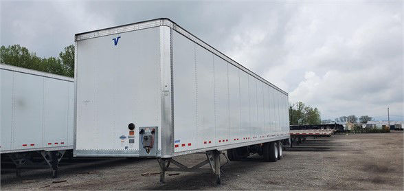 Vanguard VXP dry van trailer in a sale lot showing rectangular box with rear and side doors and wheel area.