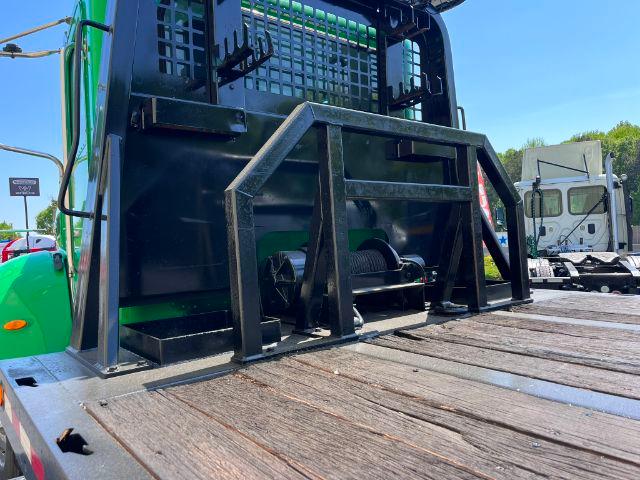 Peterbilt 348 rollback truck bed with heavy metal wheel chock and winch mount on wooden deck.