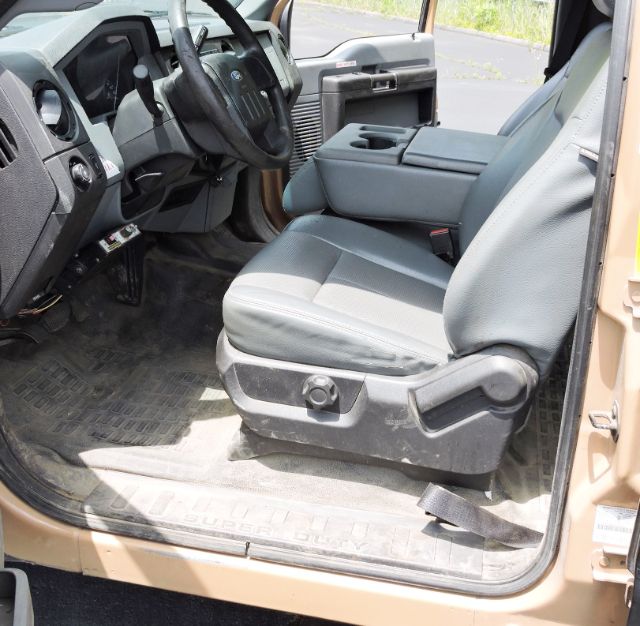 Ford F-350 crew cab interior showing driver seat and center console with rubber floor mats.