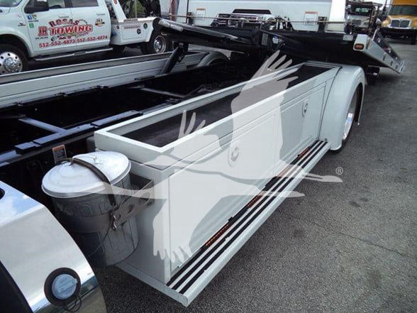 Peterbilt 337 tow truck chassis with side-mounted toolbox and fuel tank, white and black color, flatbed behind cab.
