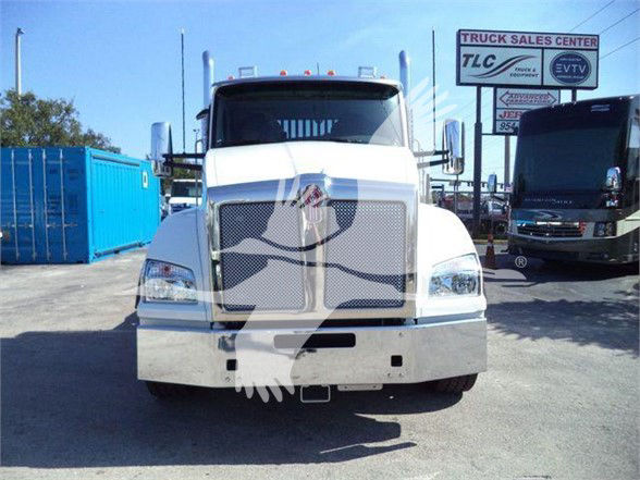 Front view of a white Kenworth T880 truck in a dealership lot with a metal bumper, large grille, and Signature Kenworth hood ornament.
