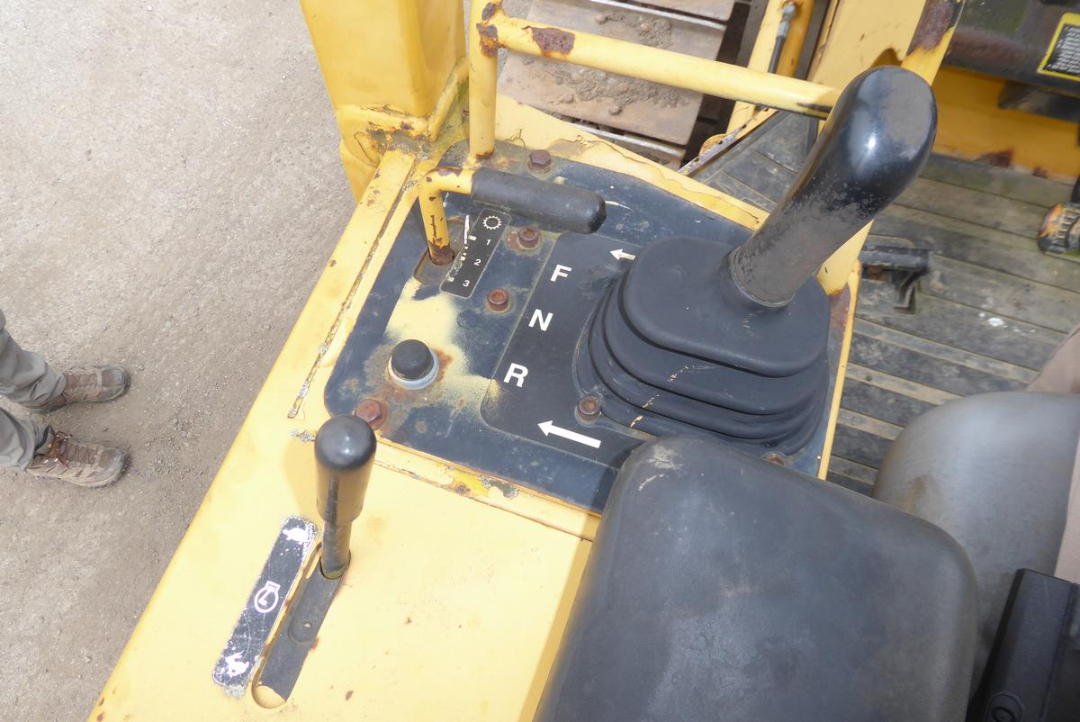 John Deere 650HLT dozer operator cockpit with forward-neutral-reverse gear lever and joystick controls.