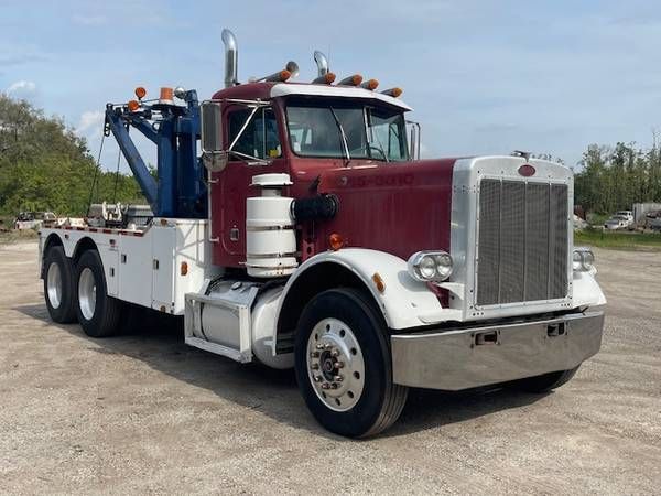 Peterbilt 359 tow truck image showing large chrome grille, maroon cab, white bumper, and towing equipment on rear chassis.