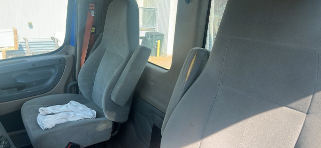 Freightliner Cascadia cab interior showing seats and steering area