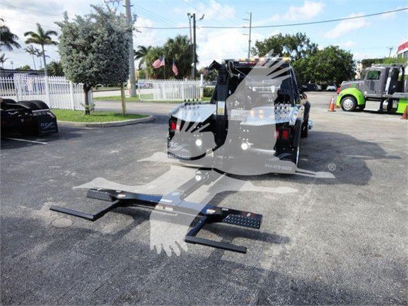 Ram 5500 SLT pickup with a hydraulic wheel-lift/tow hitch attached to the back, stock image showing equipment in a parking lot.