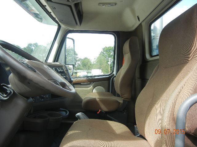 Cab and Chassis truck interior showing steering wheel, driver seat, and front passenger seat; beige fabric seats; dashboard with gauges and center console.