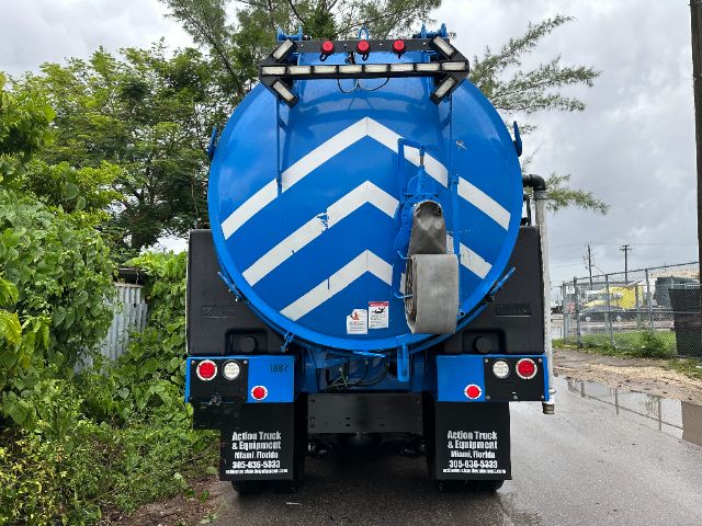 Back view of a blue 2017 Mack GU713 vacuum truck with chevron reflective stripes, rear lights, and a circular tank.