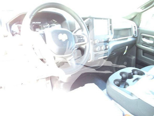 Ram 5500 interior showing steering wheel with Ram logo, center console with touchscreen, dashboard details and cup holders.