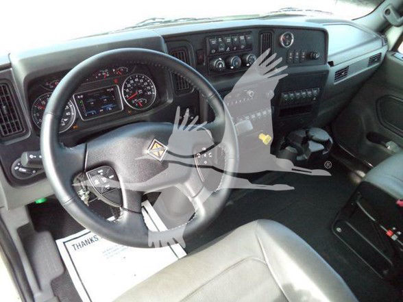 Interior of a 2025 International MV truck cab showing steering wheel and dashboard with controls and gauges.