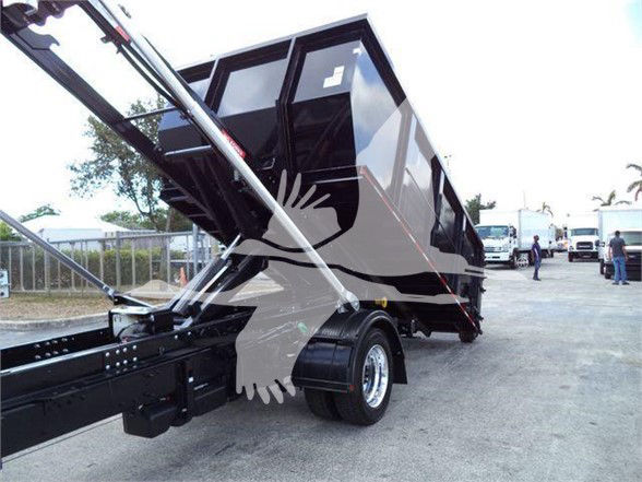 Dump truck bed in raised position showing hydraulic lift, with black chassis and large rear tires.