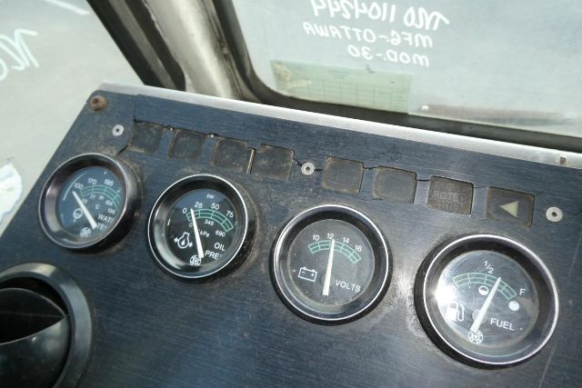 Dashboard panel with four round gauges labeled oil pressure, volts, fuel, and water/water temp, plus small indicator panels above.