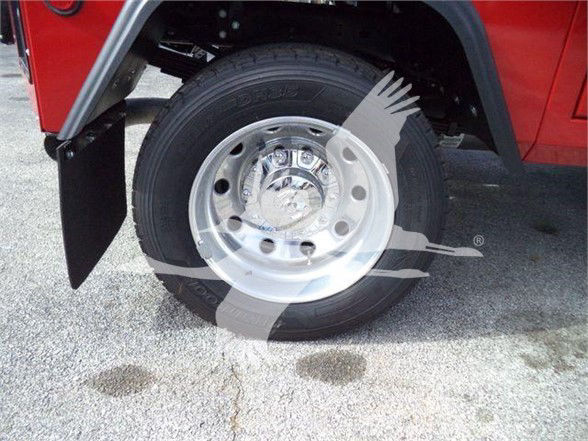 Wheel and tire on a red Ram 4500 SLT front corner showing alloy wheel and tire with fender and mud flap.