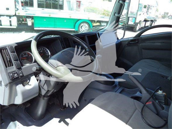 Isuzu NRR interior dashboard and steering wheel showing instrument cluster and driver seat area.