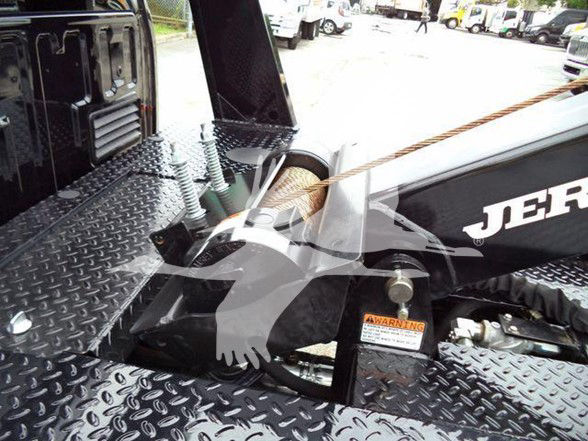 Tow truck bed area of a 2024 Ford F450 with diamond plate deck and towing equipment, warning label visible.
