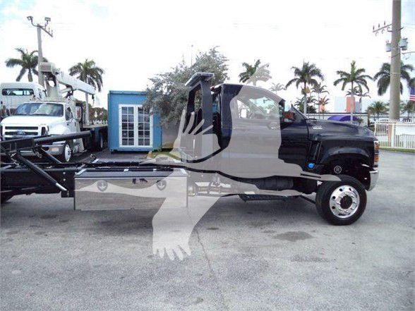 2023 International CV tow truck chassis with wheel and cab visible; watermark overlay of two hands clasping.